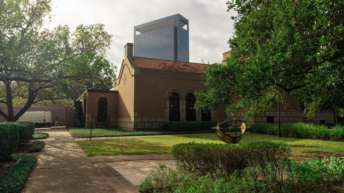 Picture shows the outside of the Cohen House, with a sculpture that looks like a compass in front.